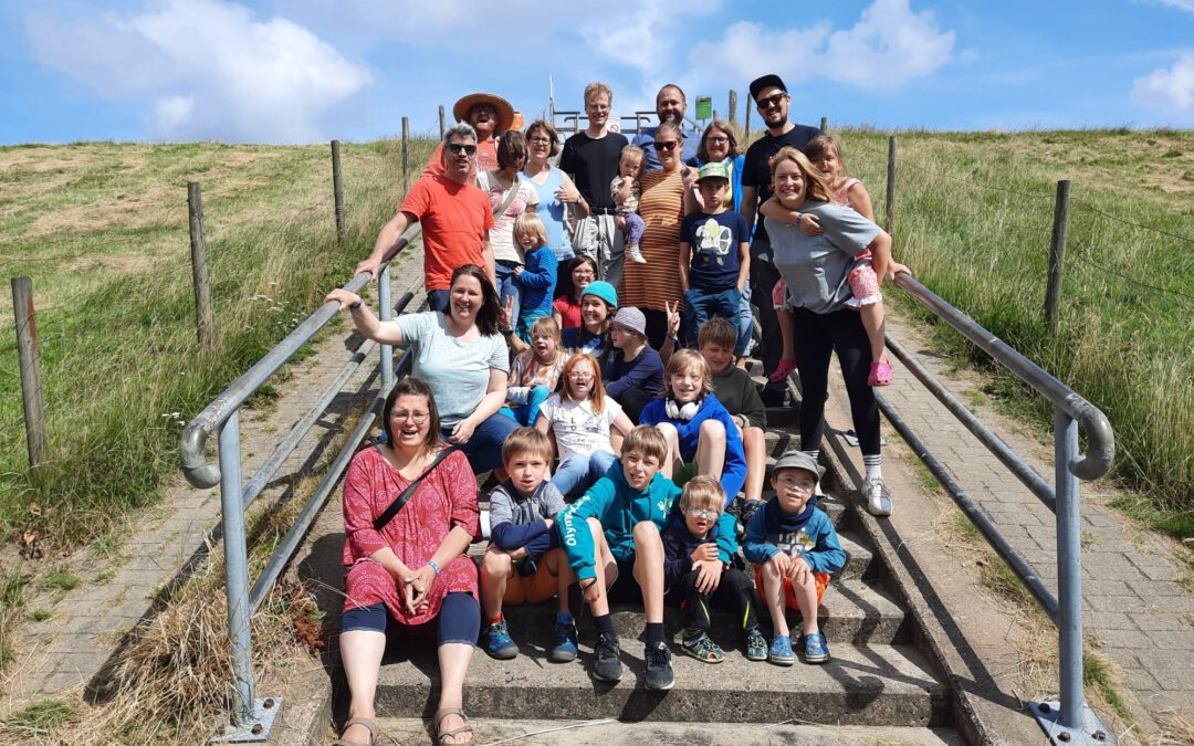 Eine Gruppe von Erwachsenen und Kindern sitzt und steht auf einer Treppe